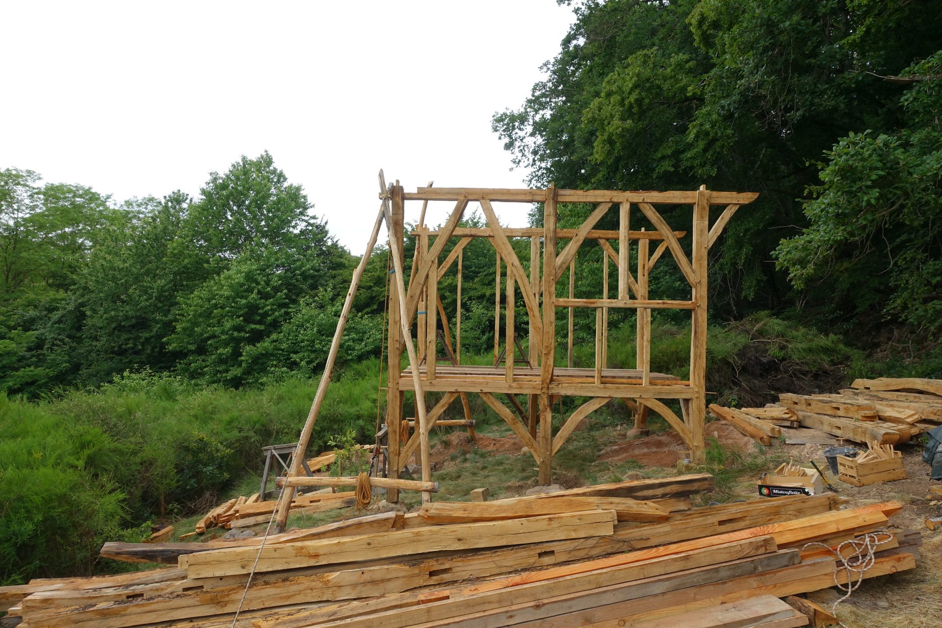 Levage grâce à une chèvre et des mouflages (cordes) d'une cabane en bois de brin